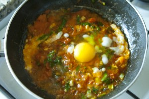 Shakshoukeh adding eggs